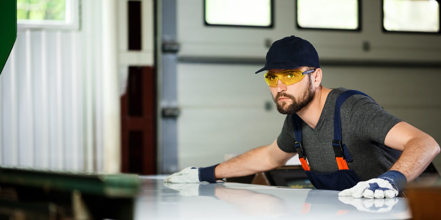 Portrait of worker in overalls, steel factory background.