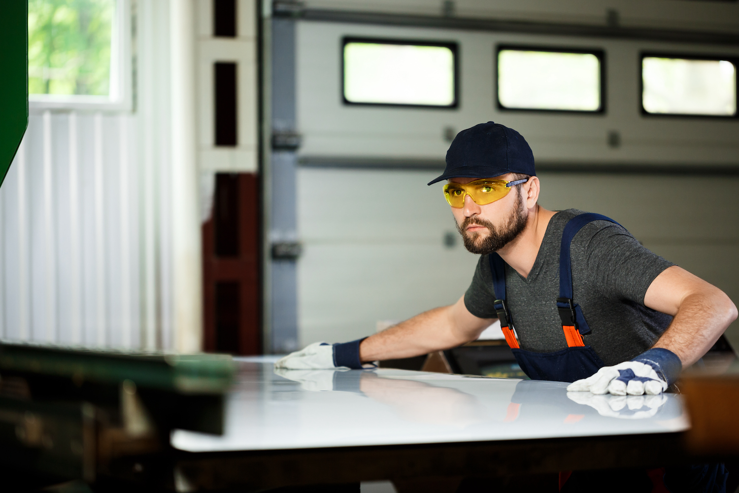 Portrait of worker in overalls, steel factory background.